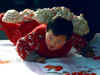 7．周歲娃把跟頭拽。1986年冬，陜西省洛南縣。孩子過歲這天，奶奶用面粉做成牛耕地所拽的犁架形狀（俗稱“跟頭”）。用紅繩拉住，讓娃娃前爬。取意是孩子從此會走路了。要像黃牛一樣為社會和家庭默默地耕耘，任勞任怨，奉獻(xiàn)自己的一生。